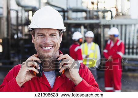 Stock Photo - Worker standing at chemical plant. Fotosearch