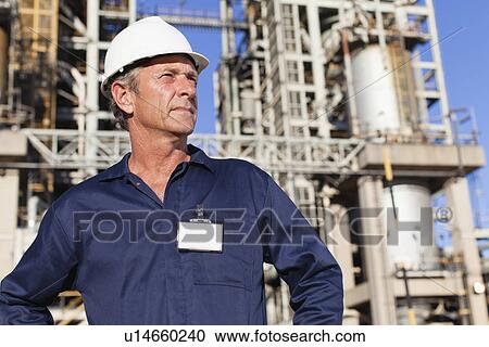 Worker standing at oil refinery View Large Photo Image Stock Image - Worker standing at oil refinery. Fotosearch