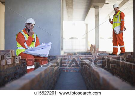 Stock Image - Worker using walkie talkie on site. Fotosearch