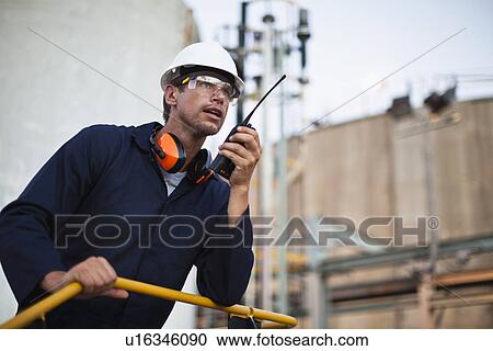 Worker using walkie talkie on site View Large Photo Image Stock Image - Worker using walkie talkie on site. Fotosearch