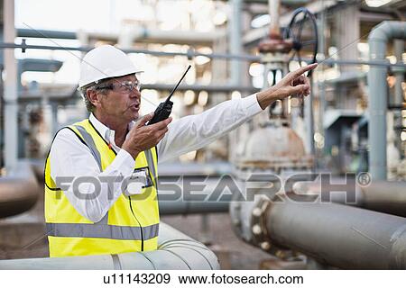 Stock Photo - Worker using walkie talkie on site. Fotosearch