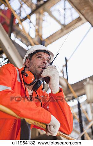 Worker with walkie talkie on site View Large Photo Image Stock Image - Worker with walkie talkie on site. Fotosearch