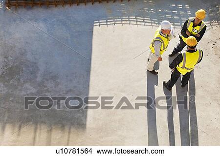 Picture - Workers casting shadows on site. Fotosearch