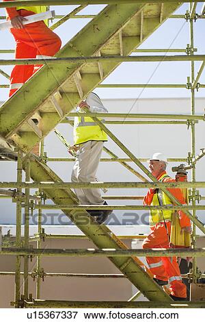 Workers climbing steps on site View Large Photo Image Stock Photo - Workers climbing steps on site. Fotosearch