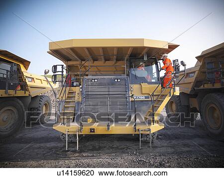 Stock Image - Workers on equipment in coal mine. Fotosearch