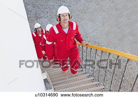 Stock Image - Workers on steps at chemical plant. Fotosearch