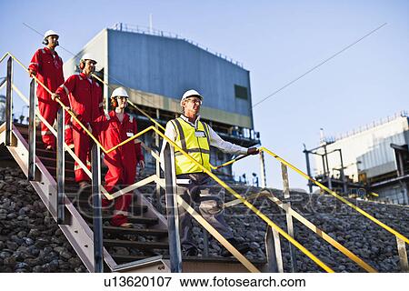 Stock Photo - Workers on steps at chemical plant. Fotosearch