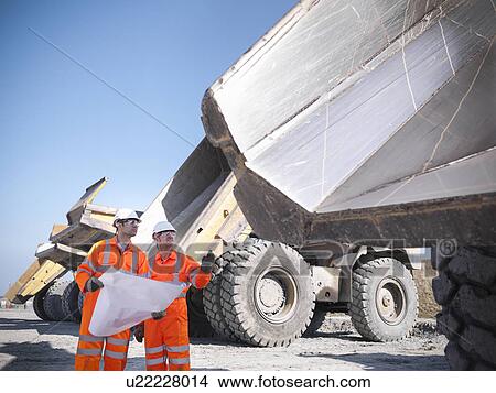 Picture - Workers reading blueprints at coal mine. Fotosearch