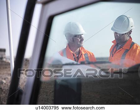 Stock Photography - Workers reading blueprints at coal mine. Fotosearch