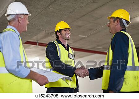 Stock Photo - Workers shaking hands on site. Fotosearch