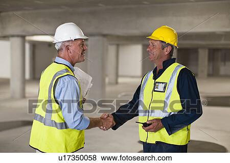 Workers shaking hands on site View Large Photo Image Stock Photo - Workers shaking hands on site. Fotosearch