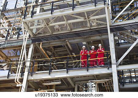 Workers standing on ledge together View Large Photo Image Stock Image - Workers standing on ledge together. Fotosearch