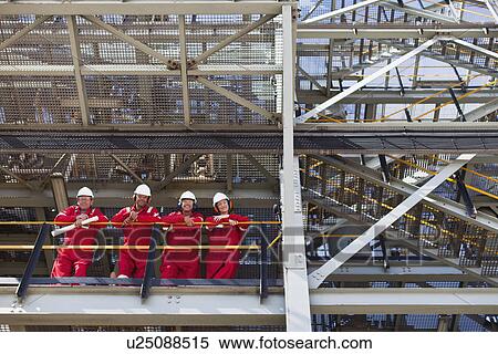 Workers standing on ledge together View Large Photo Image Stock Photography - Workers standing on ledge together. Fotosearch