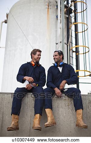 Stock Photo - Workers talking at chemical plant. Fotosearch