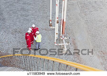 Stock Photo - Workers talking at chemical plant. Fotosearch