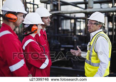 Stock Photograph - Workers talking at chemical plant. Fotosearch