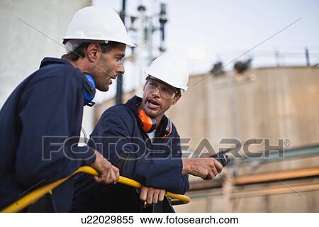 Stock Photography - Workers talking at chemical plant. Fotosearch