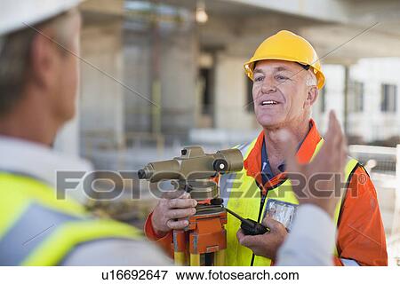 Stock Photo - Workers talking at construction site. Fotosearch
