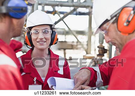 Workers talking at oil refinery View Large Photo Image Stock Image - Workers talking at oil refinery. Fotosearch