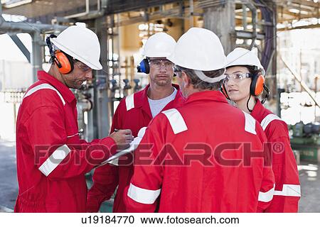 Workers talking at oil refinery View Large Photo Image Stock Image - Workers talking at oil refinery. Fotosearch