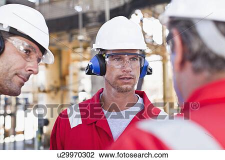 Workers talking at oil refinery View Large Photo Image Stock Image - Workers talking at oil refinery. Fotosearch