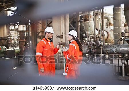 Stock Photo - Workers talking at oil refinery. Fotosearch