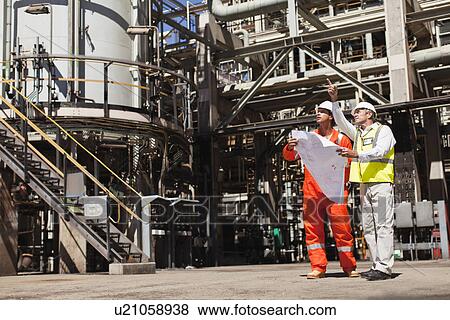 Workers talking at oil refinery View Large Photo Image Stock Photo - Workers talking at oil refinery. Fotosearch