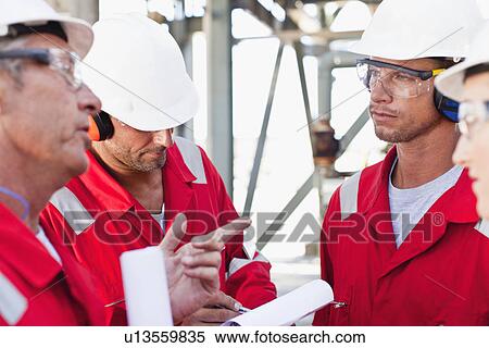 Workers talking at oil refinery View Large Photo Image Stock Photography - Workers talking at oil refinery. Fotosearch