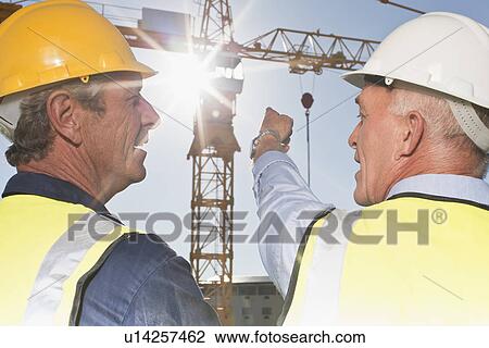 Workers talking on construction site View Large Photo Image Stock Image - Workers talking on construction site. Fotosearch