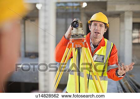 Stock Image - Workers using equipment on site. Fotosearch