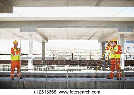 Stock Photo - Workers using equipment on site. Fotosearch