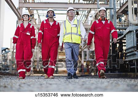 Stock Photograph - Workers walking at chemical plant. Fotosearch