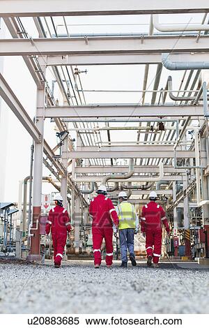Stock Photography - Workers walking at chemical plant. Fotosearch