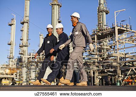 Workers walking at oil refinery View Large Photo Image Stock Image - Workers walking at oil refinery. Fotosearch