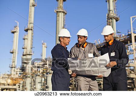 Workers with blueprints at oil refinery View Large Photo Image Stock Image - Workers with blueprints at oil refinery. Fotosearch
