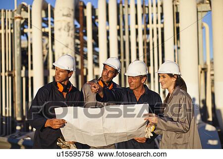 Workers with blueprints at oil refinery View Large Photo Image Stock Photo - Workers with blueprints at oil refinery. Fotosearch