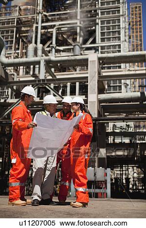 Stock Photography - Workers with blueprints at oil refinery. Fotosearch