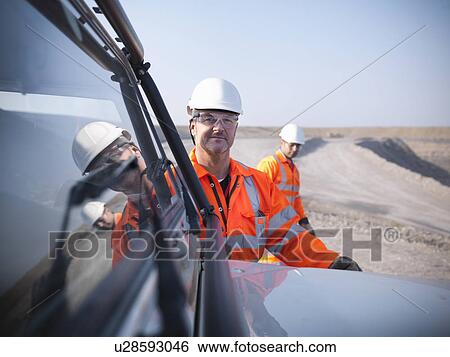 Stock Photograph - Workers with equipment in coal mine. Fotosearch