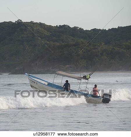 Stock Photo - Boat on wave, Sayulita, Nayarit, Mexico. Fotosearch