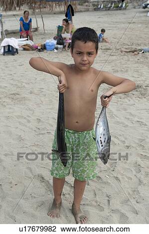 Stock Image - Boy holding fish in both hands, Sayulita, Nayarit, Mexico. Fotosearch