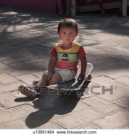 Picture - Boy sitting on a skateboard, Sayulita, Nayarit, Mexico. Fotosearch