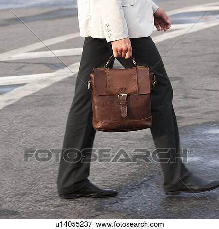 Businessman walking on the road, St. Petersburg, Russia View Large Photo Image Stock Photo - Businessman walking on the road, St. Petersburg, Russia. Fotosearch