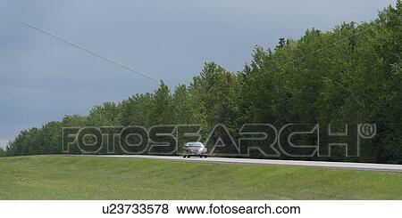 Car on a road, Northern Alberta, Alberta, Canada View Large Photo Image Stock Photo - Car on a road, Northern Alberta, Alberta, Canada. Fotosearch