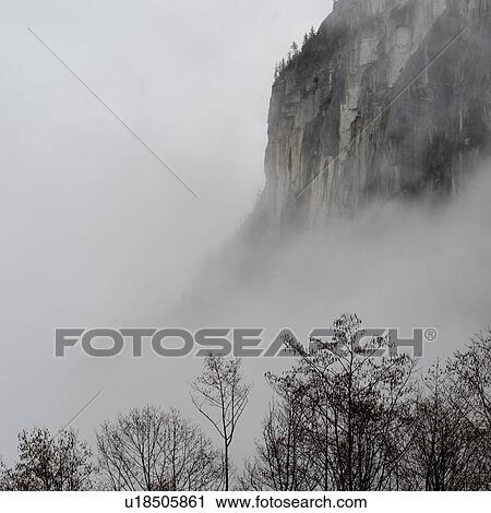 Stock Image - Cliff surrounded with fog, Shannon Falls Provincial Park, British Columbia, Canada. Fotosearch