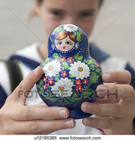 Stock Photography - Close-up of a girl showing a Russian nesting doll, St. Petersburg, Russia. Fotosearch
