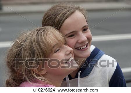 Picture - Close-up of a teenage girl smiling with her sister, St. Petersburg, Russia. Fotosearch