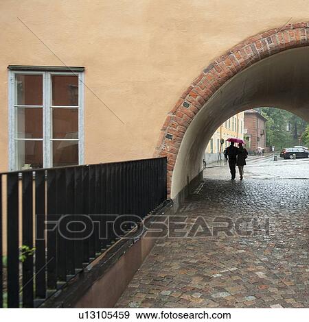 Stock Photo - Couple passing through an archway, Valvgatan, Uppsala University, Uppsala, Sweden. Fotosearch