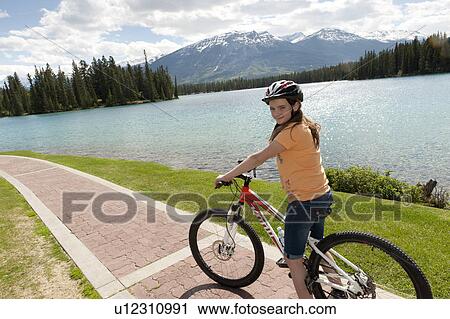 Girl riding a bicycle, Beauvert Lake, Jasper National Park, Alberta, Canada View Large Photo Image Stock Image - Girl riding a bicycle, Beauvert Lake, Jasper National Park, Alberta, Canada. Fotosearch