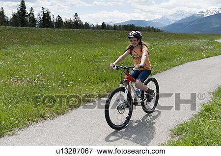Stock Photo - Girl riding a bicycle, Jasper National Park, Alberta, Canada. Fotosearch