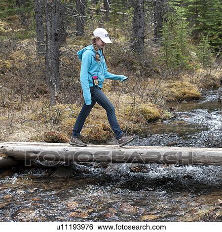 Stock Photograph - Girl walking on a fallen log, Bald Hills, Jasper National Park, Alberta, Canada. Fotosearch
